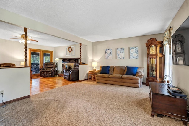 living room featuring plenty of natural light, ceiling fan, light hardwood / wood-style floors, and a textured ceiling