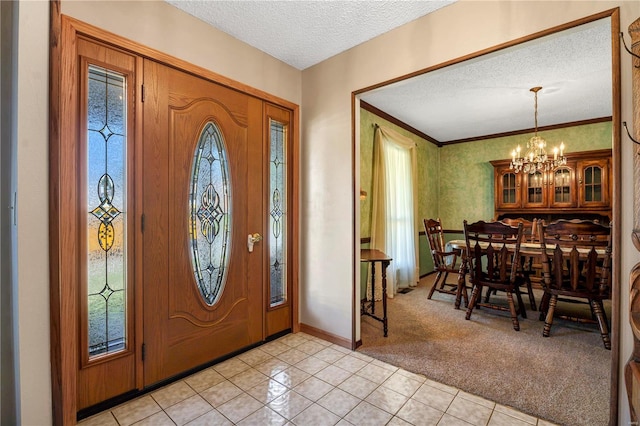 foyer entrance with ornamental molding, an inviting chandelier, light tile patterned floors, and a textured ceiling