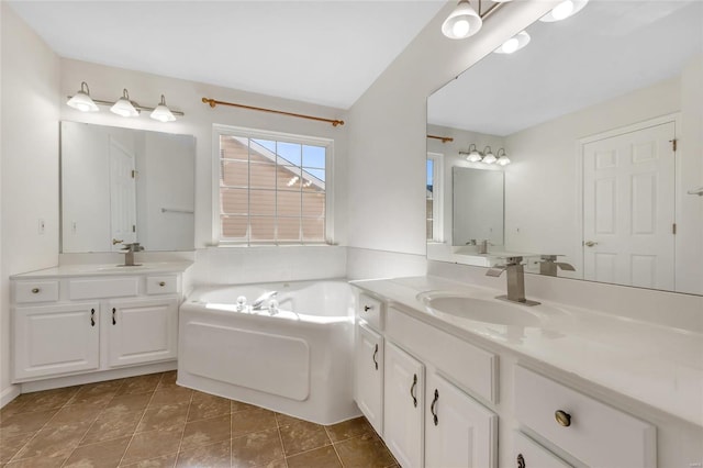 bathroom featuring tile patterned flooring, vanity, and a washtub