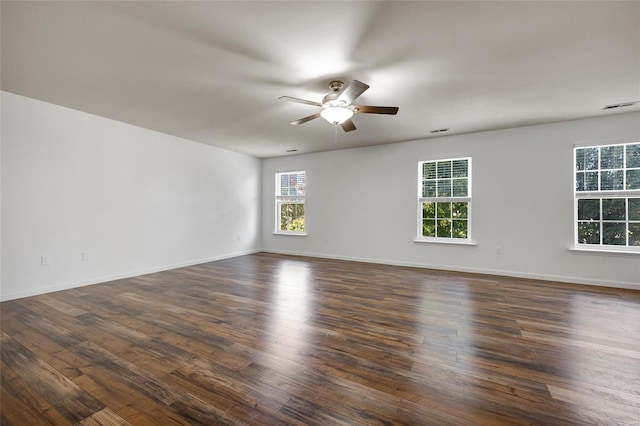 spare room featuring ceiling fan, a wealth of natural light, and dark hardwood / wood-style flooring