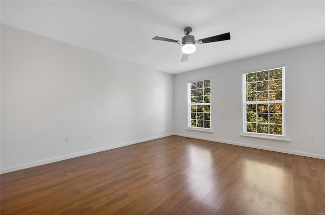 empty room featuring ceiling fan and dark hardwood / wood-style flooring