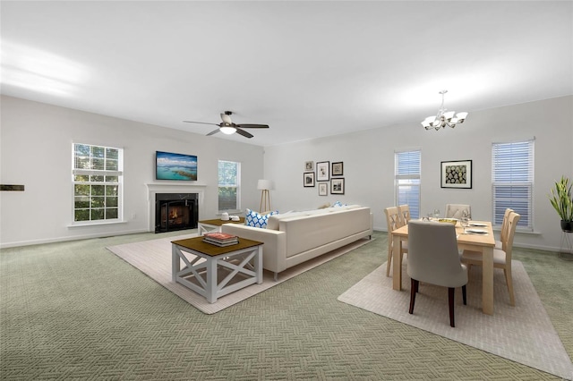 living room with ceiling fan with notable chandelier, carpet floors, and a wealth of natural light