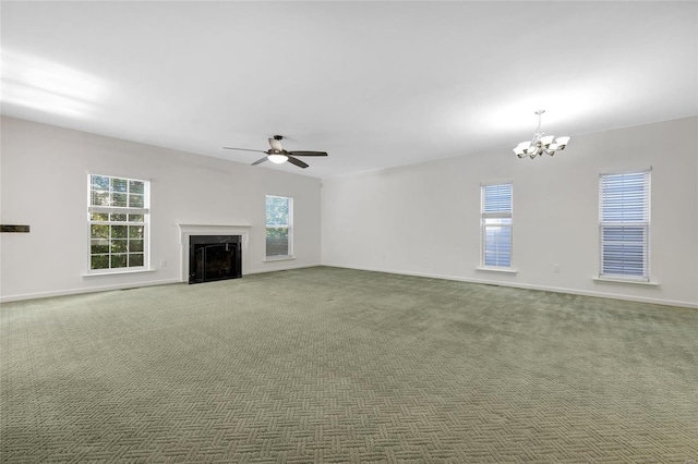 unfurnished living room with dark carpet and ceiling fan with notable chandelier