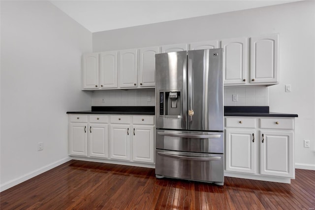 kitchen with white cabinets, stainless steel fridge, dark hardwood / wood-style floors, and tasteful backsplash