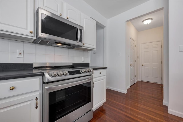 kitchen with appliances with stainless steel finishes, white cabinetry, dark hardwood / wood-style flooring, and decorative backsplash