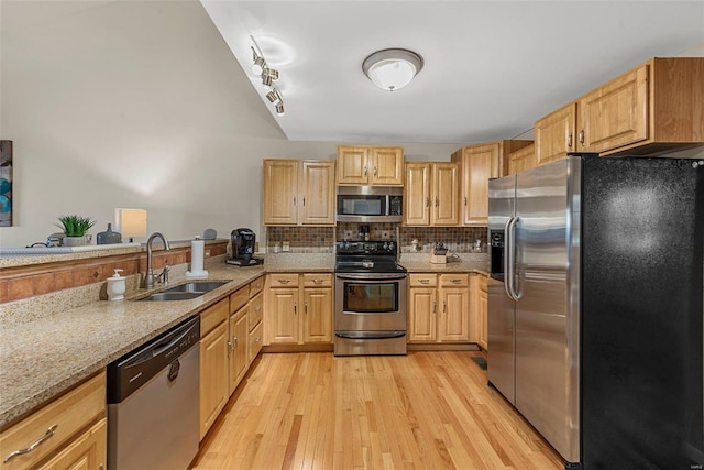 kitchen with light brown cabinetry, appliances with stainless steel finishes, light wood-type flooring, and sink