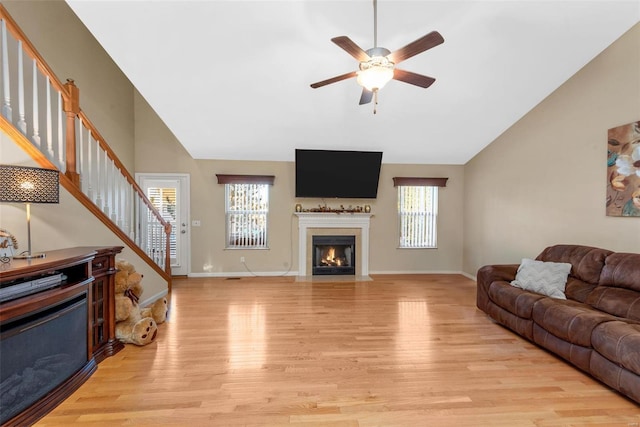 living room featuring plenty of natural light, high vaulted ceiling, light wood-type flooring, and ceiling fan