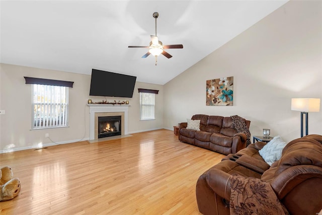 living room featuring ceiling fan, lofted ceiling, light hardwood / wood-style floors, and a wealth of natural light