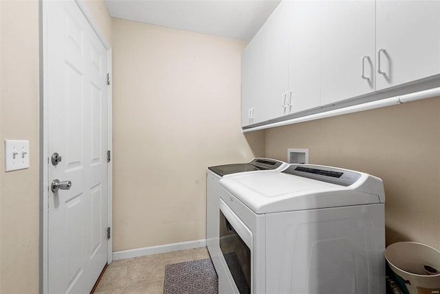 clothes washing area featuring washing machine and dryer, light tile patterned floors, and cabinets