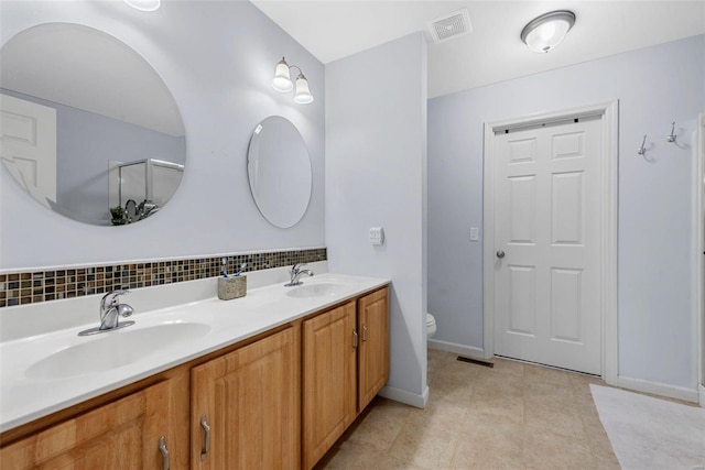 bathroom with vanity, toilet, tasteful backsplash, and tile patterned floors