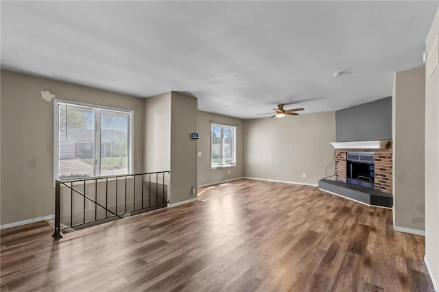 unfurnished living room featuring a fireplace, ceiling fan, and hardwood / wood-style floors