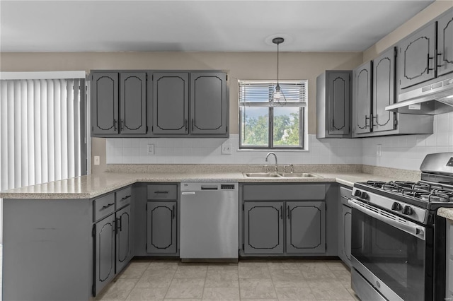 kitchen featuring appliances with stainless steel finishes, gray cabinets, sink, and tasteful backsplash