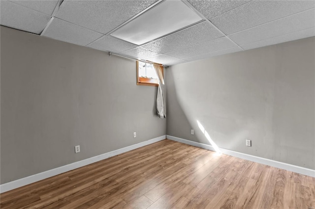 basement featuring a drop ceiling and hardwood / wood-style floors