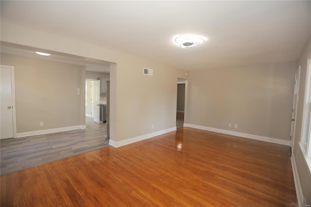 unfurnished room with dark hardwood / wood-style flooring