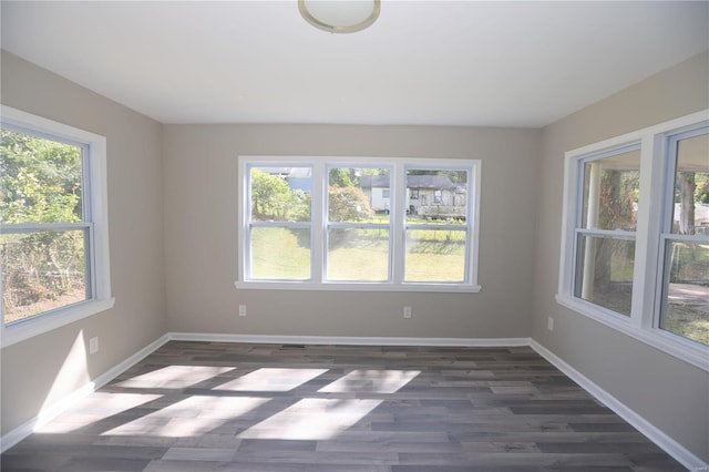 unfurnished room with dark wood-type flooring and plenty of natural light