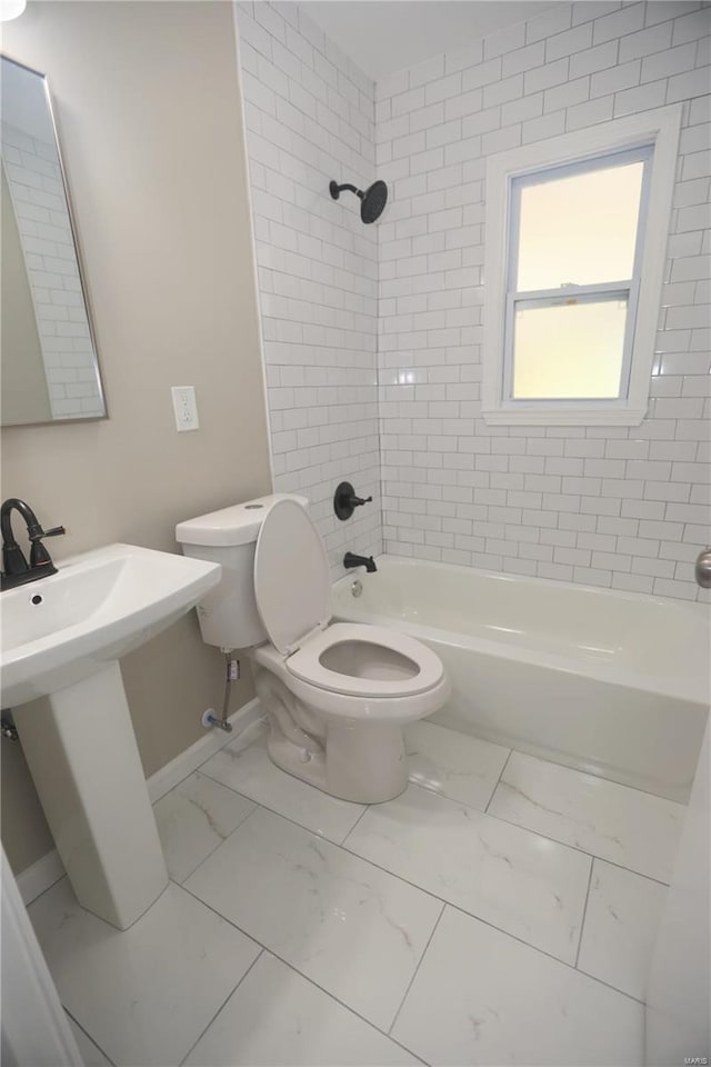 bathroom featuring tiled shower / bath combo and toilet