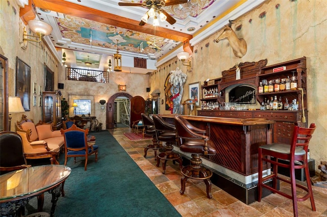 bar featuring ceiling fan, a raised ceiling, pendant lighting, a towering ceiling, and crown molding