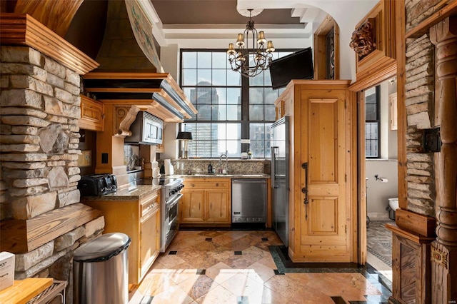 kitchen with a notable chandelier, hanging light fixtures, sink, and premium appliances