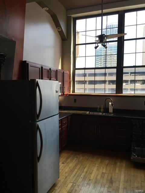 kitchen with light hardwood / wood-style floors, a healthy amount of sunlight, stainless steel refrigerator, and sink