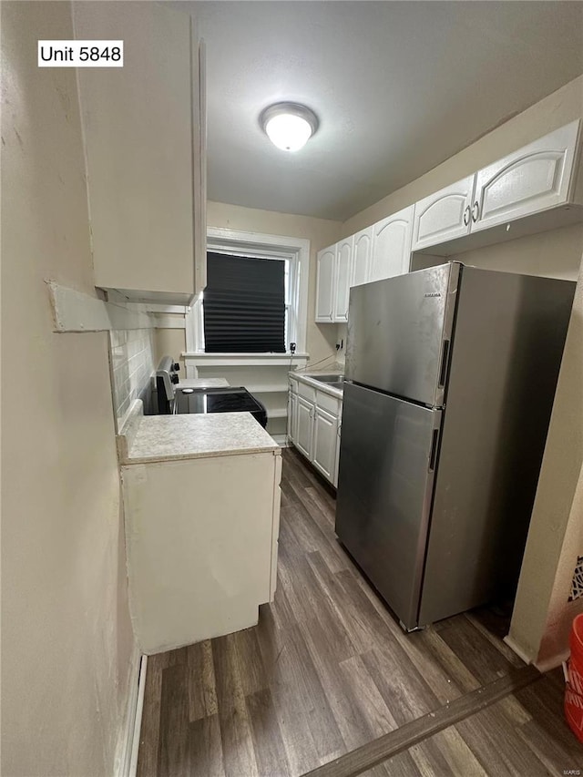 kitchen with white cabinetry, appliances with stainless steel finishes, dark hardwood / wood-style flooring, and decorative backsplash