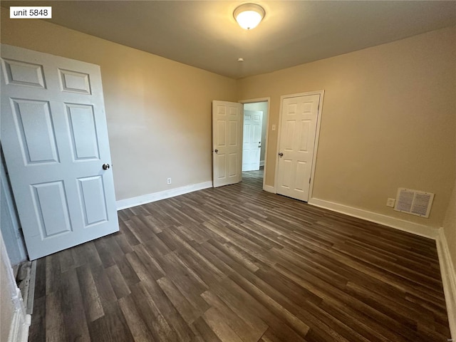 unfurnished bedroom featuring dark hardwood / wood-style flooring