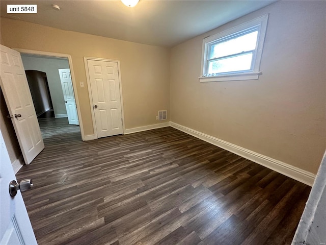 spare room featuring dark wood-type flooring