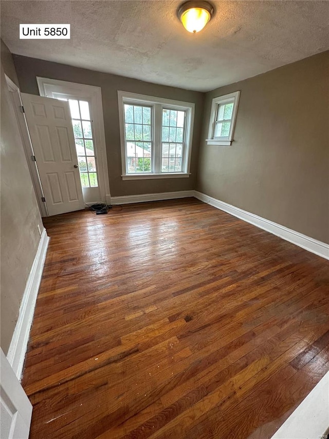 interior space featuring a textured ceiling and dark hardwood / wood-style floors