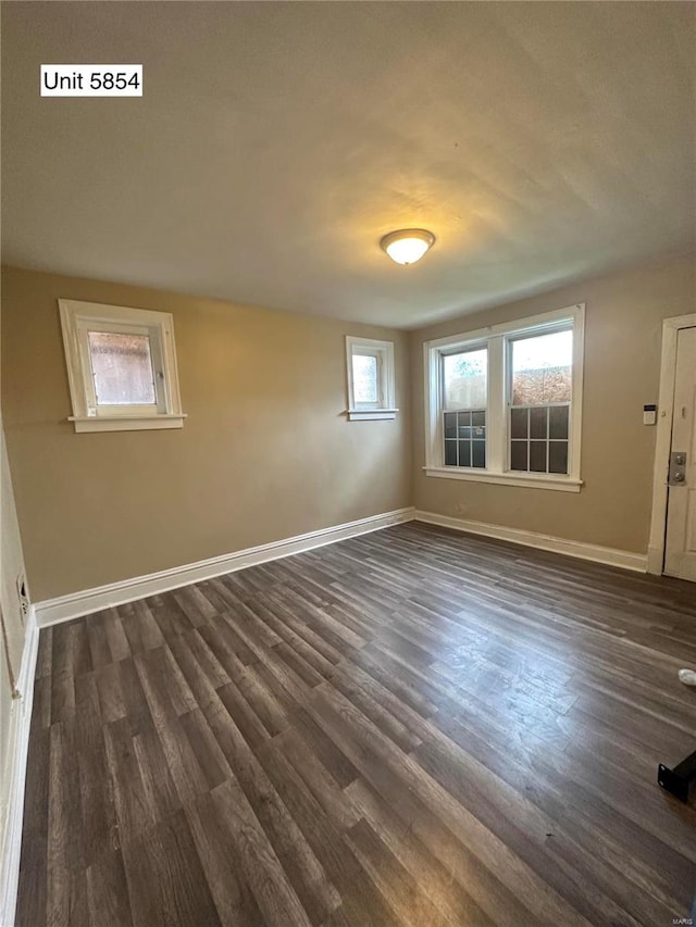 empty room featuring dark wood-type flooring and plenty of natural light