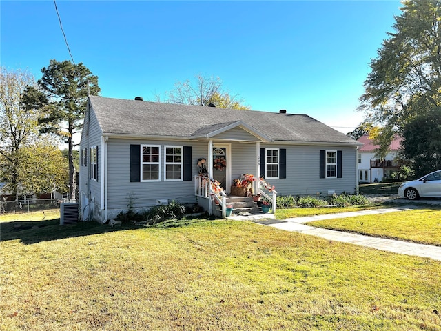 view of front of home featuring cooling unit and a front yard