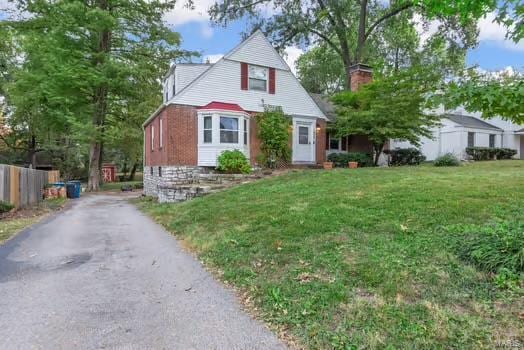 view of front of home with fence, a front lawn, and driveway