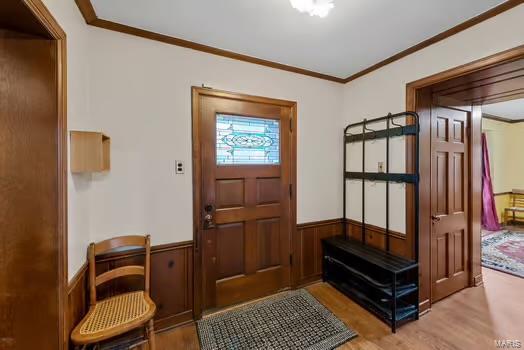 mudroom featuring crown molding, hardwood / wood-style flooring, and wooden walls