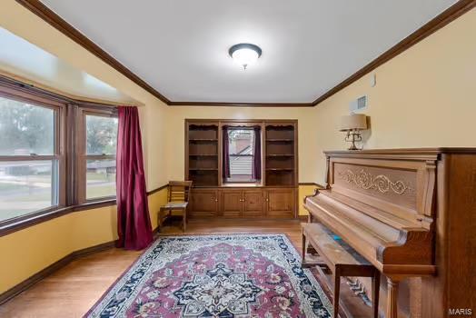 miscellaneous room with crown molding and light hardwood / wood-style flooring