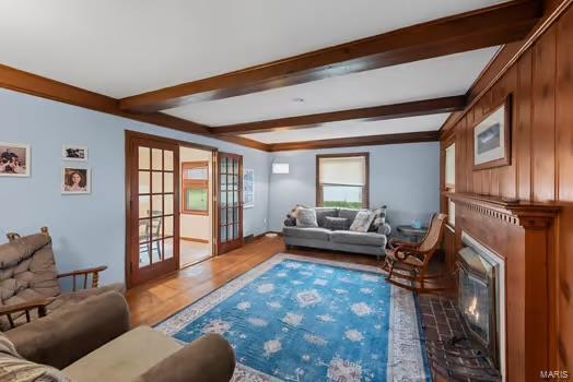 living room with beamed ceiling, wood finished floors, french doors, and a glass covered fireplace