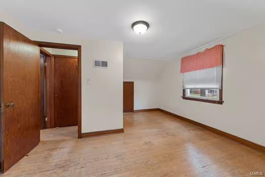 bonus room with visible vents, wood finished floors, and baseboards