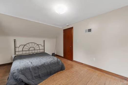 bedroom featuring visible vents, wood finished floors, and baseboards