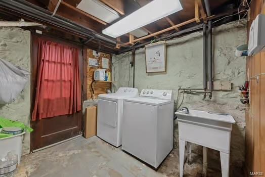 laundry area with separate washer and dryer, laundry area, and a sink