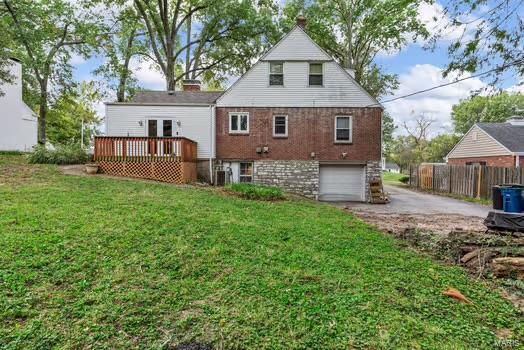 back of house featuring a wooden deck, a yard, and a garage