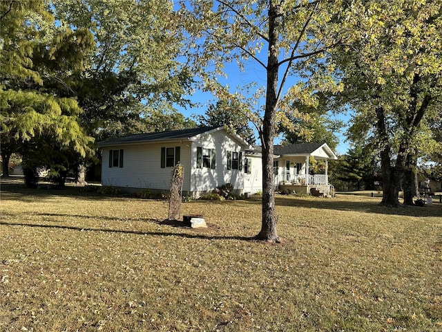 view of property exterior with a porch and a lawn