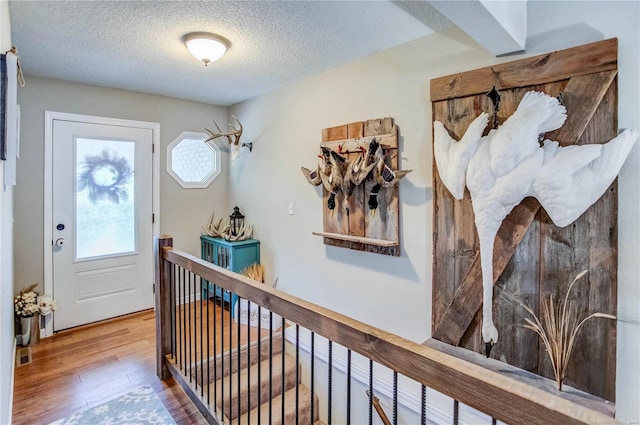 foyer entrance featuring hardwood / wood-style flooring and a textured ceiling