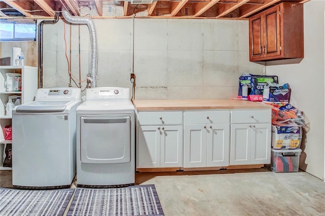 clothes washing area with cabinets and washing machine and dryer