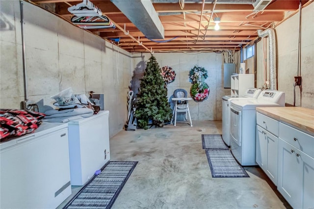 laundry area with cabinets, electric panel, and separate washer and dryer