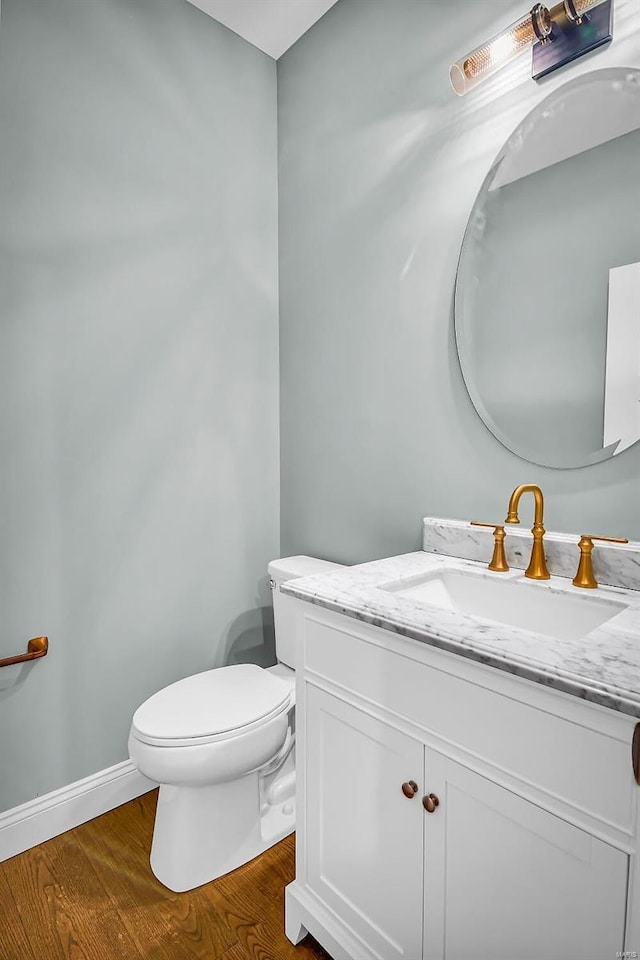 bathroom with hardwood / wood-style flooring, vanity, and toilet