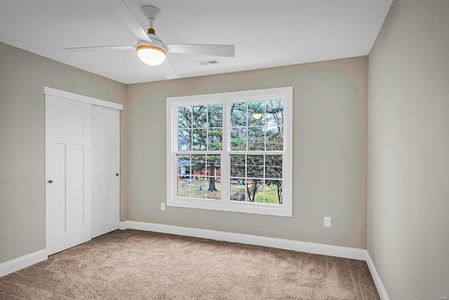 empty room with carpet flooring and ceiling fan