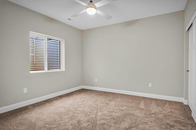 carpeted spare room with ceiling fan