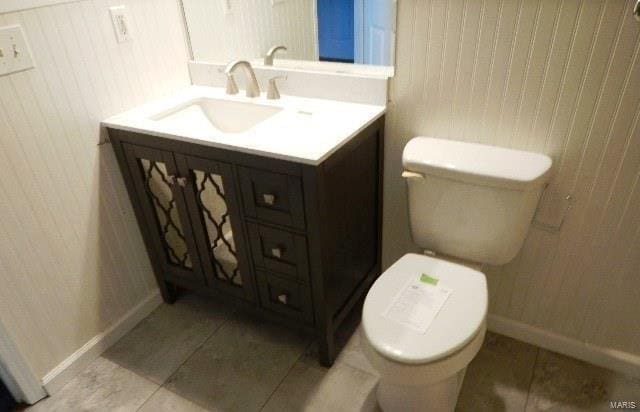 bathroom with tile patterned flooring, vanity, and toilet