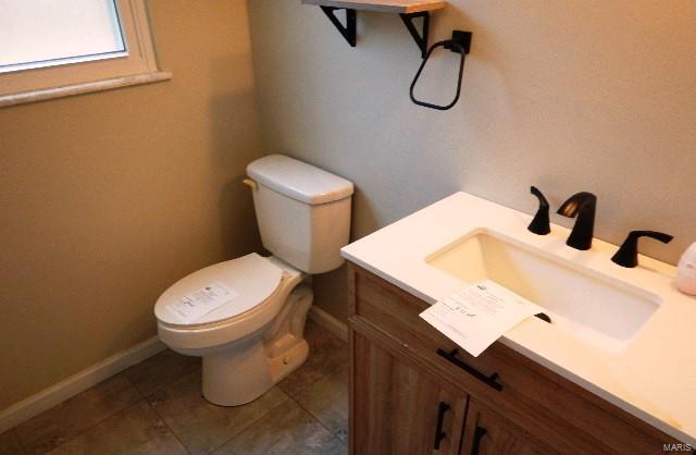 bathroom featuring tile patterned flooring, vanity, and toilet