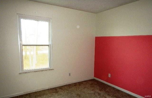 empty room with dark colored carpet