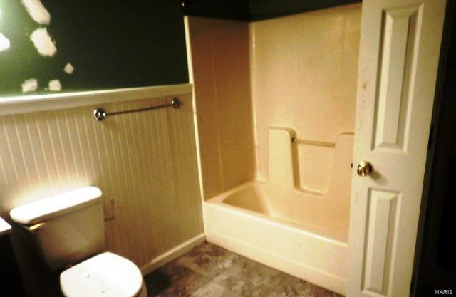 bathroom with bathtub / shower combination and toilet