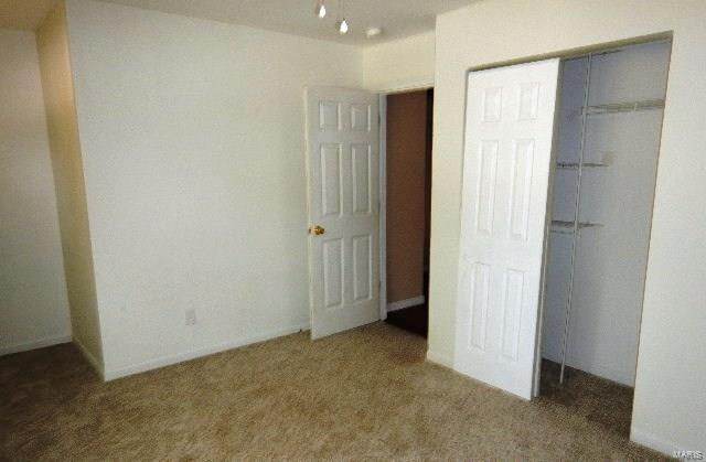 unfurnished bedroom featuring carpet and a closet