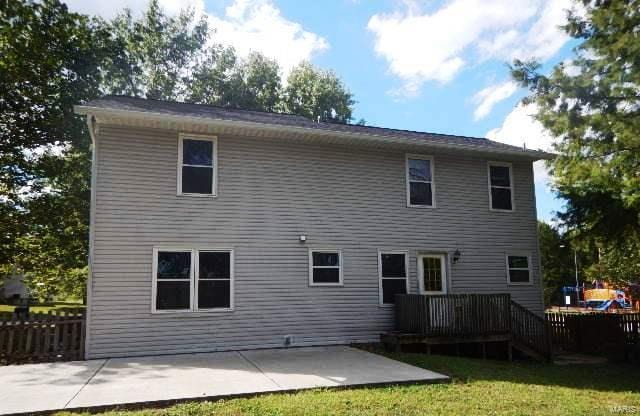 rear view of property featuring a yard, a patio, and a deck